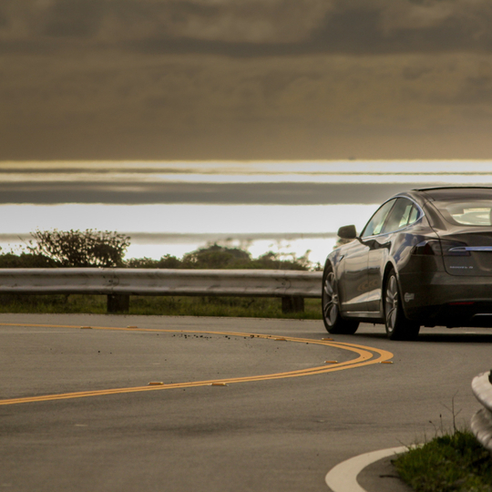 selective focus photo of gray Tesla coupe on road